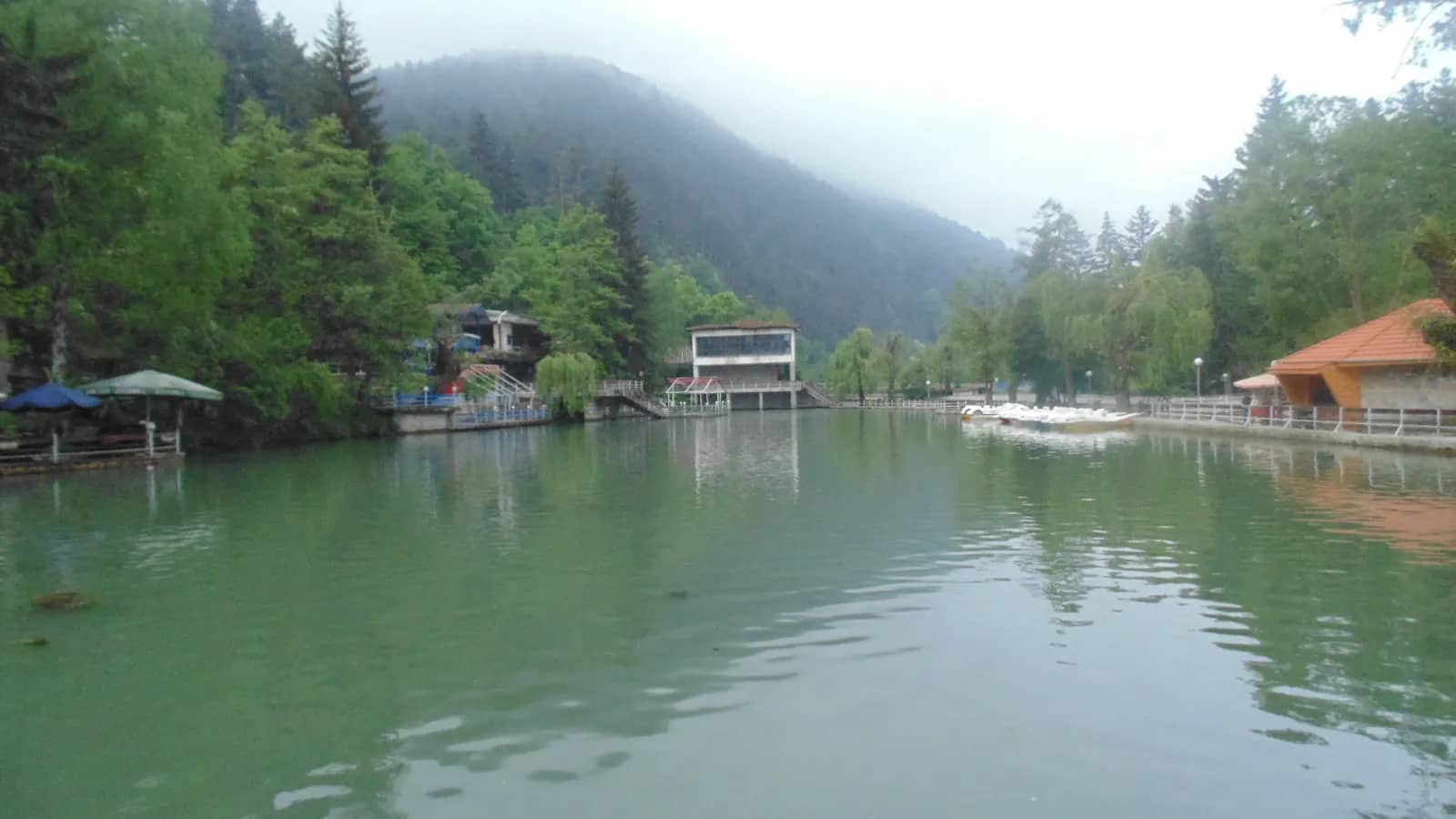 Lake Kleptuza in Velingrad, green water between forested hills in mist