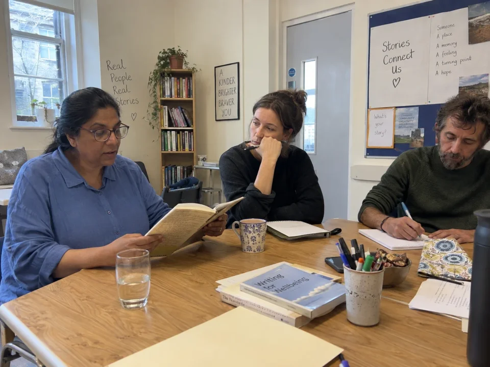 A small creative writing group sharing stories and writing in notebooks